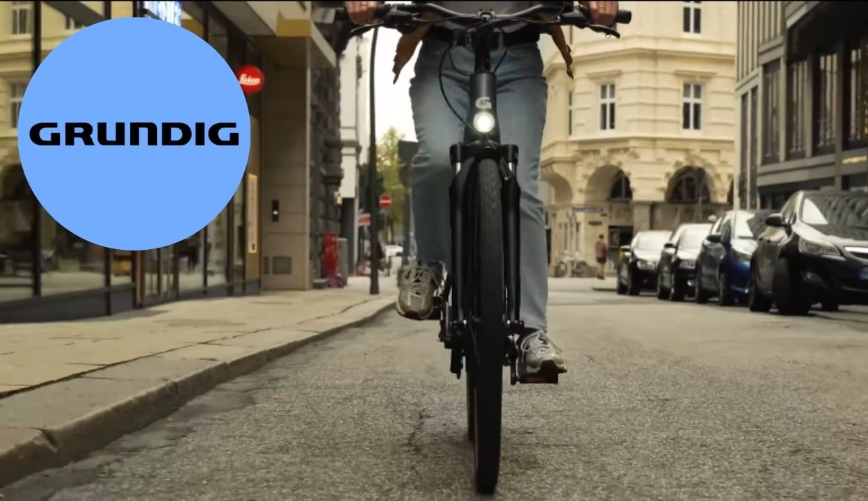 Grundig e-bike case study cover with a cyclist riding an e-bike through a city street
