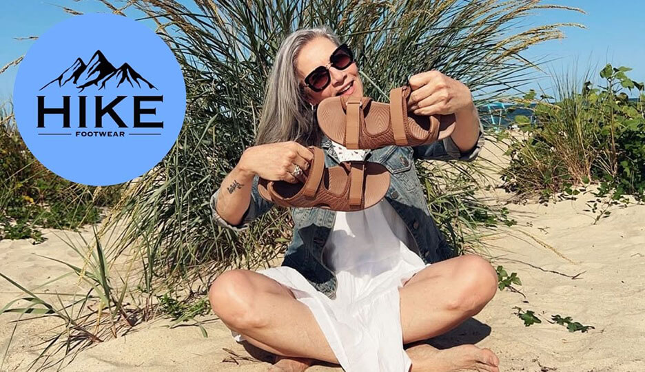 Hike Footwear case study cover with a woman holding brown sandals on a beach